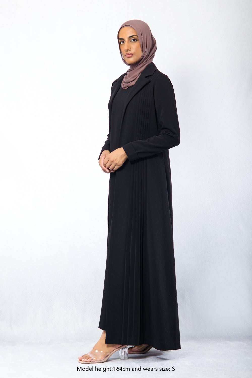 Side profile of modest black Amani Pleated Blazer Set with pleated front panels, styled for formal occasions