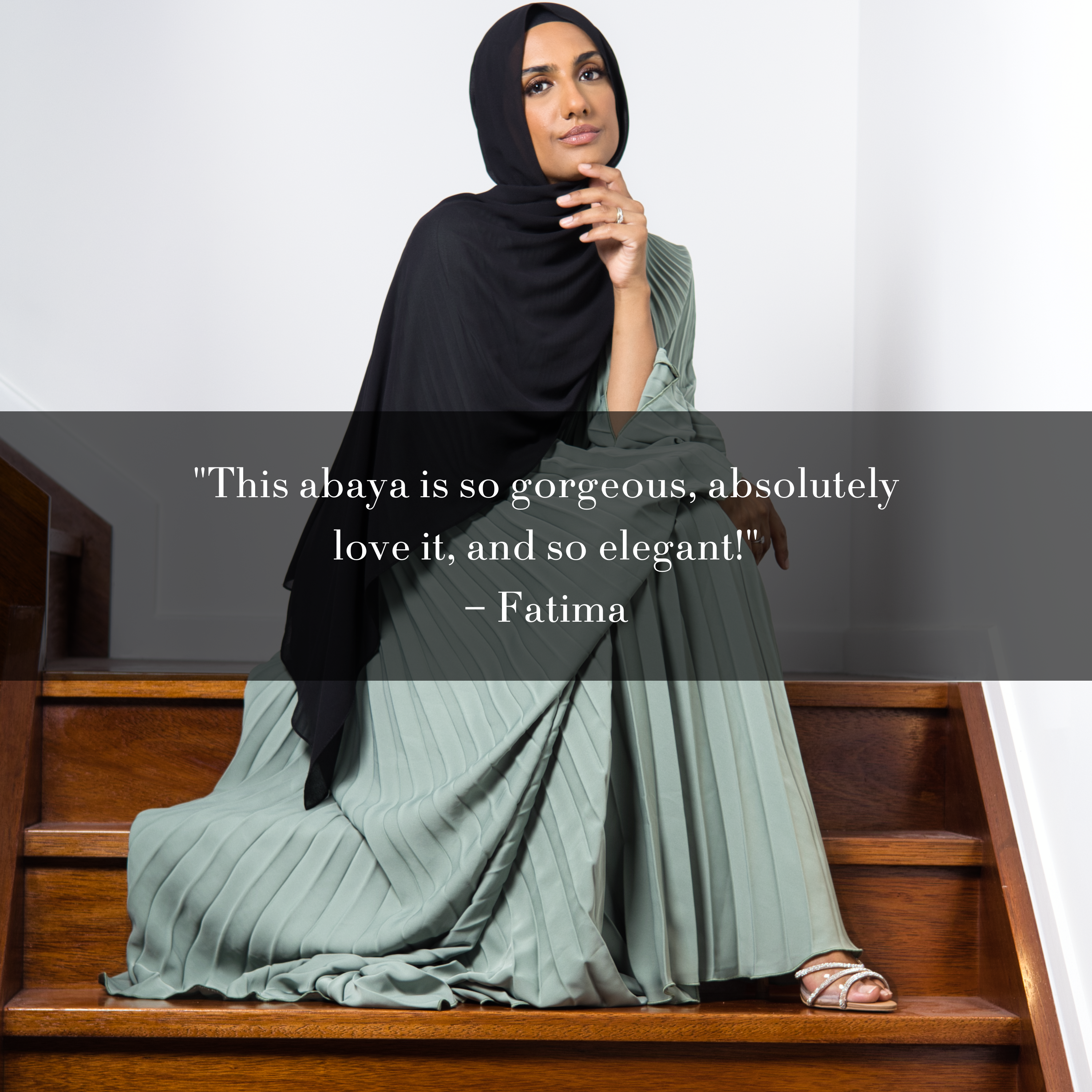 Muslim woman wearing sage green pleated abaya and black hijab seated on stairs, with customer testimonial overlay praising elegance and beauty of the outfit.